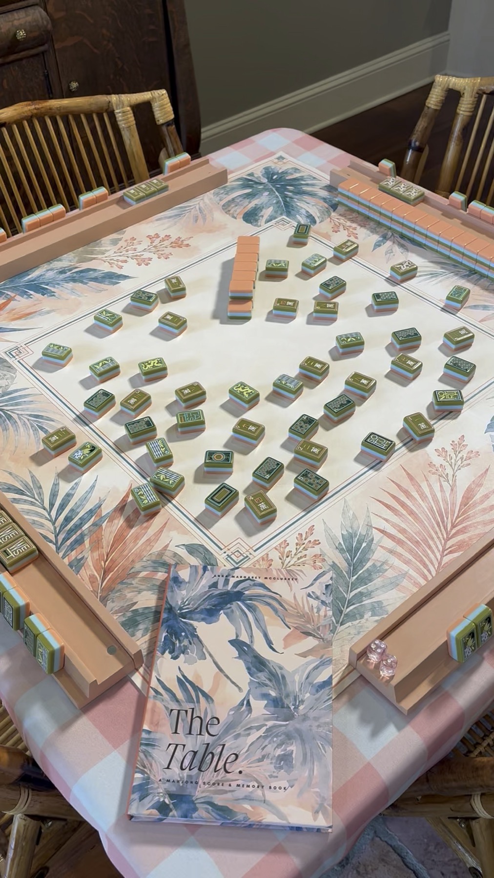 The Table scorebook styled on a pink tropical Mahjong table with tiles and racks