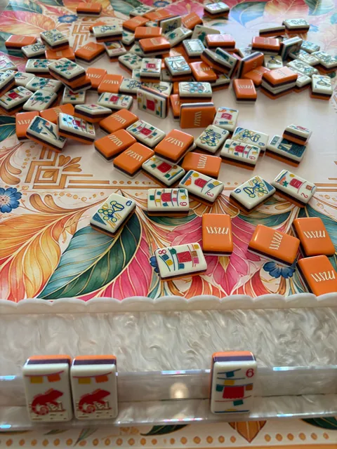 Close table view of orange Mahjong tiles on the Universal Tropics mat